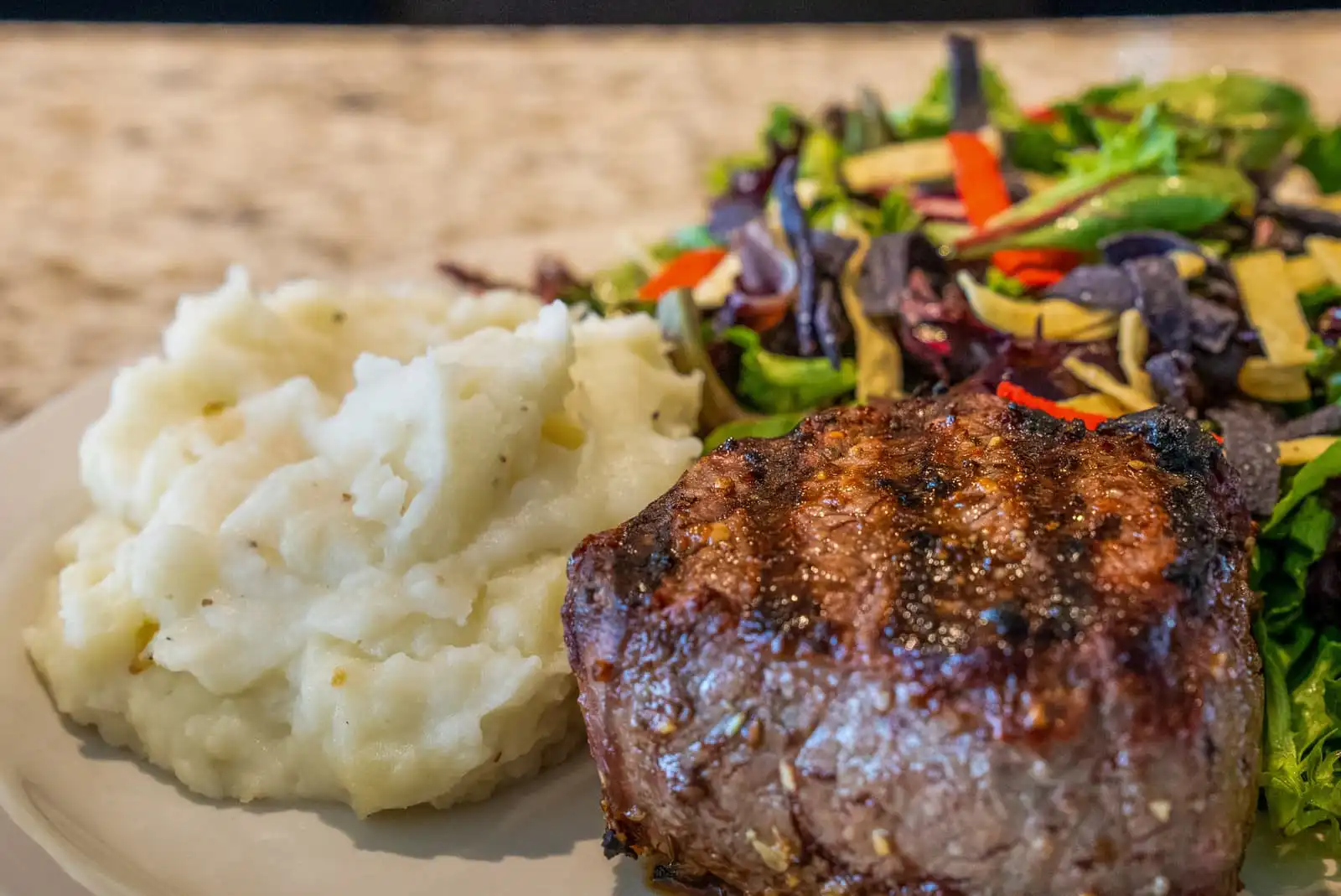 A close up of a steak dinner with mashed potatoes and side salad at Executive Inn & Suites - Embarcadero Cove